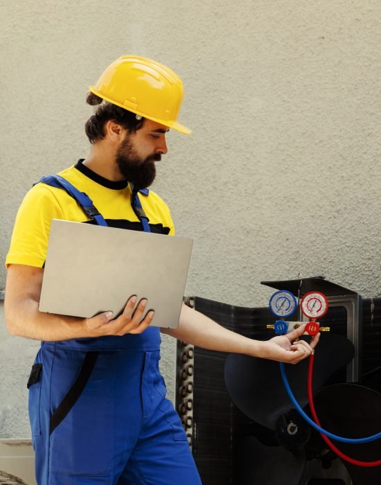 Smiling competent mechanic calibrating pressure measurement device during comissioned air conditioner troubleshooting. Adept repairman reading vacuum pressure of condenser liquids and gases